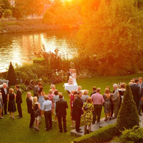 wedding festivities taking place on a riverside at sunset