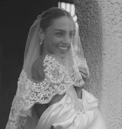 women smiling underneath wedding veil