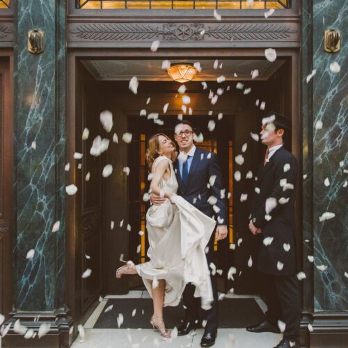 confetti being thrown on a couple during a wedding ceremony