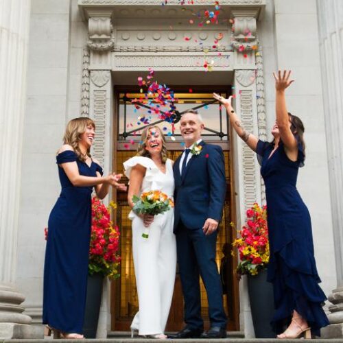 confetti being thrown on couple during wedding ceremony