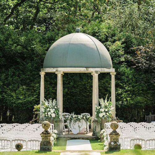 An outdoor wedding ceremony event space with pergola