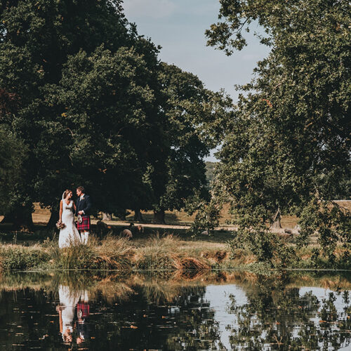 A newly married couple walking past a river