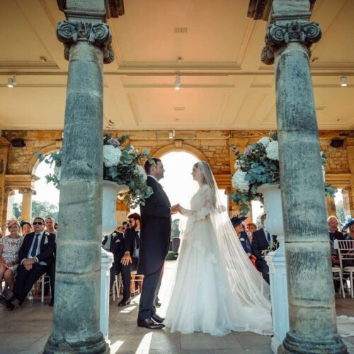 Couple exchanging vows in from of arched door space