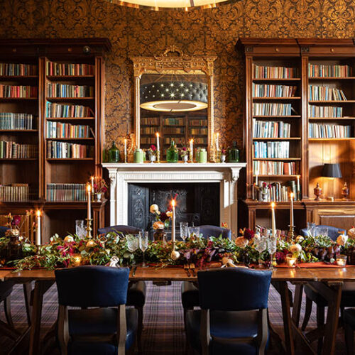 Indoor wedding dining space with fireplace and bookshelves.