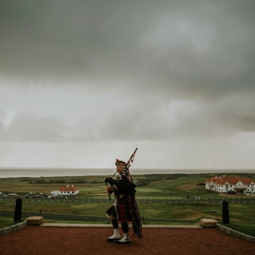 Man playing the bagpipes with an aesthetic backdrop